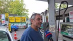 Ein Mann wird bei einer Tankstelle interviewt