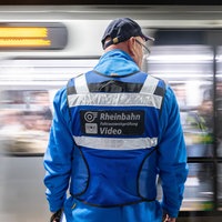 Ein Rheinbahn-Mitarbeiter steht vor einer fahrenden U-Bahn