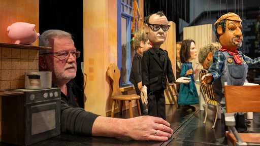 Theaterleiter Klaus Marschall rückt in der Augsburger Puppenkiste die Marionette von Friedrich Merz (CDU) in die Szene des Kabarettstücks "Das Ende der Ampel-WG"