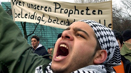"Wer unseren Propheten beleidigt, beleidigt uns alle" steht auf einem Transparent von Demonstranten