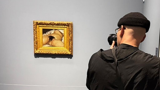 Fotograf vor Gemälde mit Frauenakt