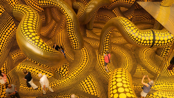 Kusamas "Infinity Mirrored Room" ist ein großer Raum aus gelb gepunkteten, schwarzen Tentakeln