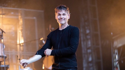 Morten Harket hält bei einem Auftritt im Jahr 2018 eine Sonnenbrille in der Hand und krempelt sich die Ärmel hoch