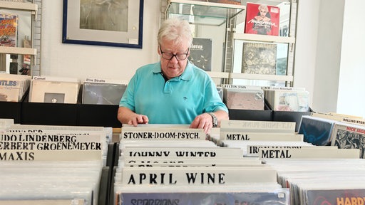 Sammler Werner Besancon steht im Plattenladen und geht die Schallplatten durch.