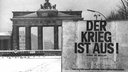 Plakat vor dem Brandenburger Tor mit der Aufschrift "Der Krieg ist aus"
