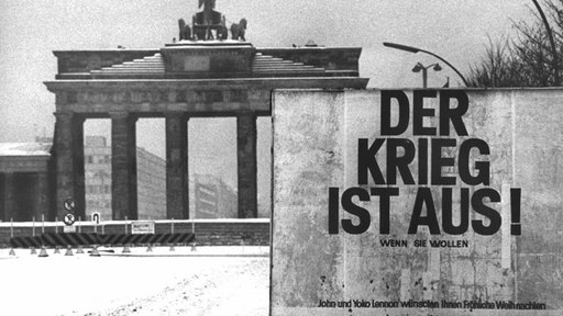 Plakat vor dem Brandenburger Tor mit der Aufschrift "Der Krieg ist aus"