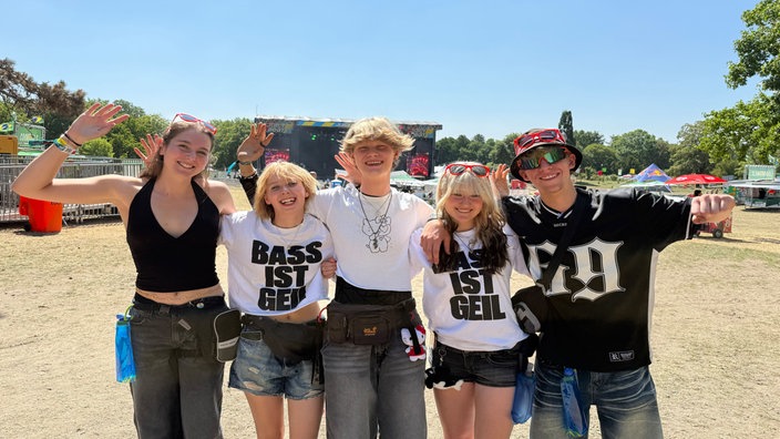 Fünf Jugendliche winken lächelnd beim Juicy Beats Musikfestival in Dortmund.