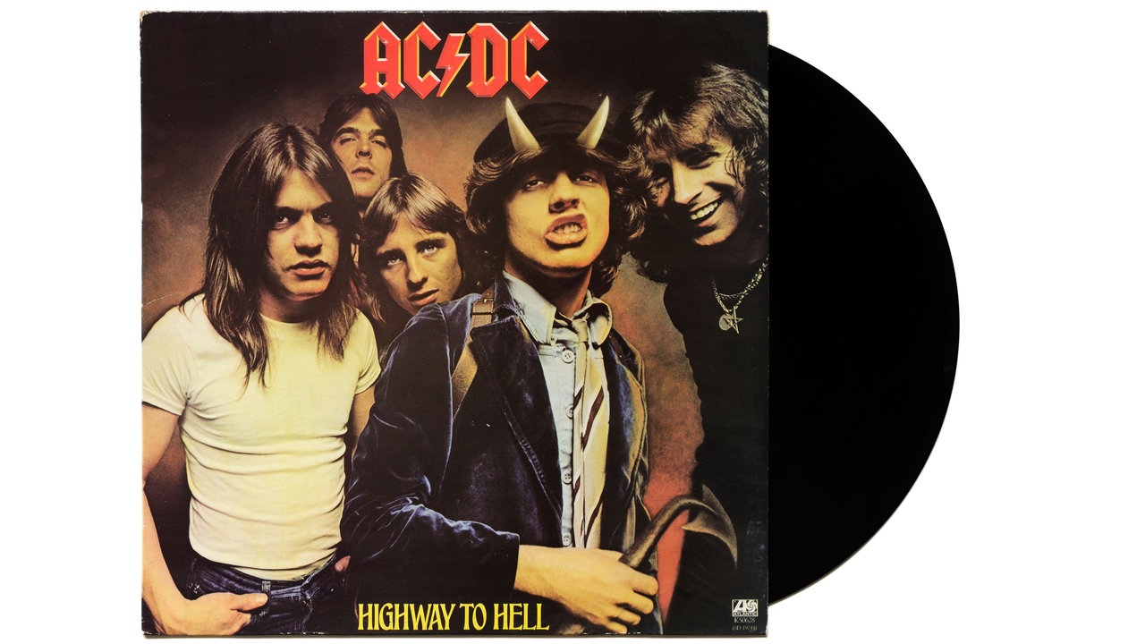 Das Cover des Albums "Highway to Hell" von AC/DC zeigt die fünf Bandmitglieder, teils lachend, teils grimmig dreinblickend. Leadgitarrist Angus Young trägt Teufelshörner und blickt Zähne fletschend in die Kamera 