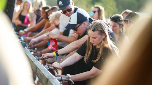 Besucher holen sich an einer Wasserstation kostenloses Trinkwasser beim Parookaville-Festival. 