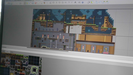 Ein Bildschirm zeigt eine mittelalterliche Welt in Pixel-Graphik.