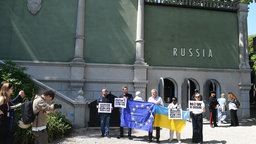 Vor dem russischen Pavillon auf der Biennale in Venedig protestieren im Mai 2026 mit Plakaten gegen die Teilnahme Russlands.