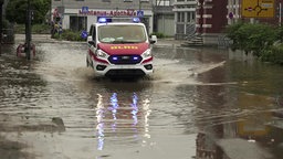Ein Fahrzeug der DLRG fährt durch eine überflutete Straße