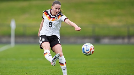 Die Fußballspielerin Leonie Köpp schießt einen Fußball