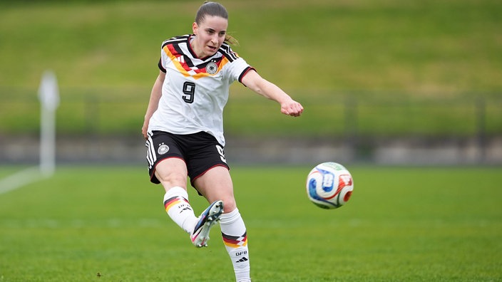 Die Fußballspielerin Leonie Köpp schießt einen Fußball