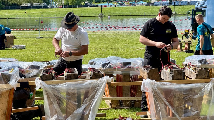 Zwei Pyrotechniker bereiten das Feuerwerk vor
