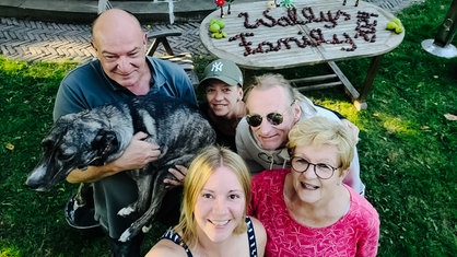 Ein Gruppenselfie mit fünf Personen und einem Hund.