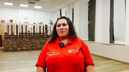 Stefanie Wintzen steht in einem roten Polo des Karnevalsverein in der Tanzschule.