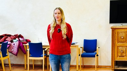 Maike Schmidt, eine Frau mit langen blonden Haaren, steht in einem Kursraum.