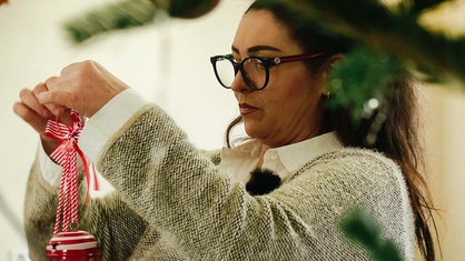 Tanja Hoffmann schaut auf den Christbaumschmuck, den sie in den Händen hält.