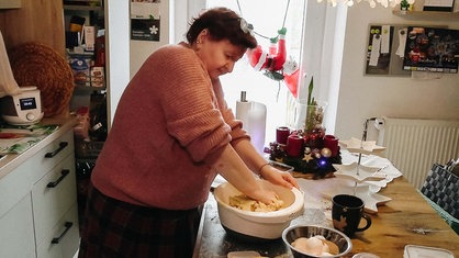 Cordula Lüchters steht in ihrer Küche. Ihre Hände kneten Teig in einer Schüssel.