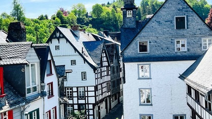 Eine kleine Straße mit weißen Fachwerkhäusern in Monschau.