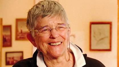 Margret Bodemann in ihrem Wohnzimmer. Sie lacht.