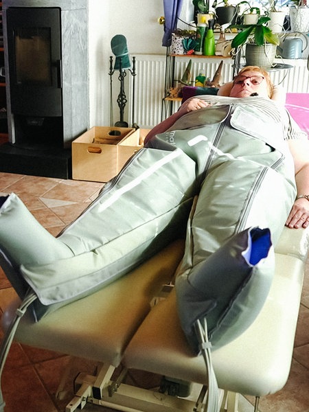 Monika Schulte liegt auf einem Bett, ihr Körper steckt in einer Art Anzug.