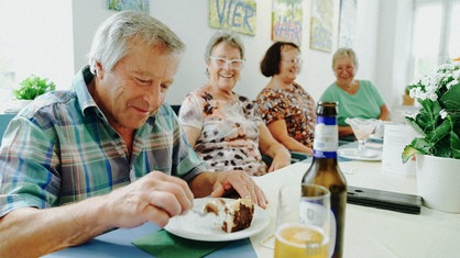Josef Kremer und seine Wandergruppe sitzen beim Kuchen zusammen.