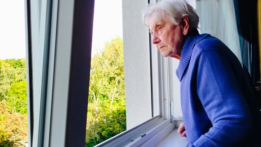 Anneliese Götte schaut aus einem Fenster ihres Elternhauses.