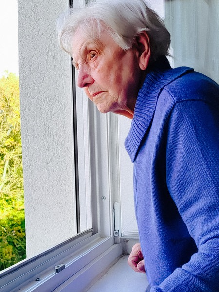 Anneliese Götte schaut aus einem Fenster ihres Elternhauses.