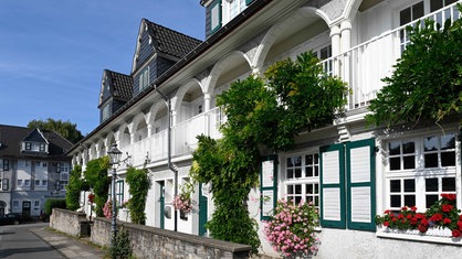 Eine Zeile von Häusern mit weißen Fassaden und Fensterläden in der Essener Siedlung Margarethenhöhe