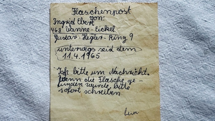 Braun-gelblicher Zettel, darauf steht handgeschrieben "Flaschenpost" und die Daten von Ingrid Arendsen