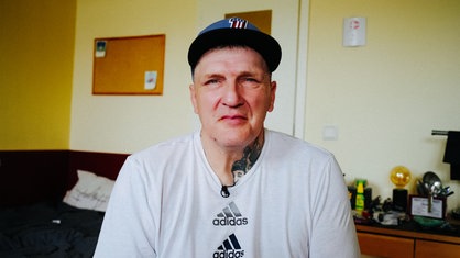 Ein Mann mit Kappe schaut in die Kamera