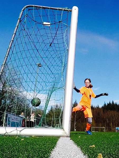 Torhüterin Anna Louisa versucht einen Ball der gegenerischen Spielerinnen zu halten, der jedoch ins Netz geht.