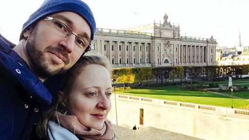 Selfie von Judith, einer blondhaarigen Frau, neben László, einem großen Mann mit Dreitagebart und Brille.