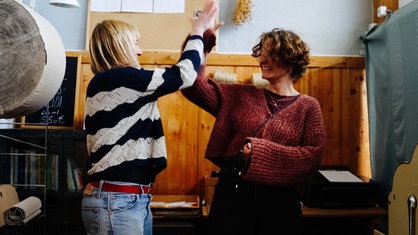 Zwei Frauen geben sich ein Highfive.