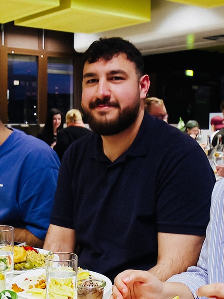 Enes Türedioğlu mit Freunden am Tisch in der Mensa