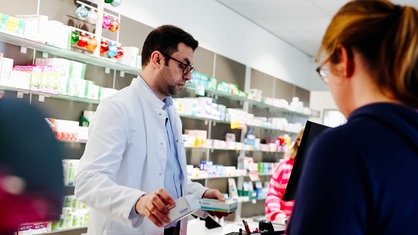 Kaniwar Mohamed im Kontakt mit einer Kundin in der Apotheke.