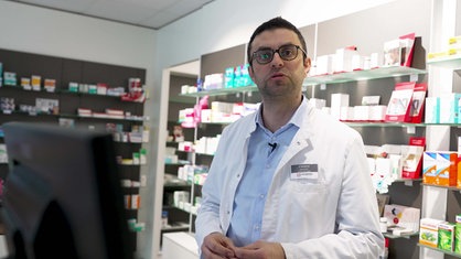 Apotheker Kaniwar Mohamed steht in der Harener Apotheke in Bad Wünnenberg, im Hintergrund Regale mit Medikamenten