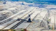 Ein Loch aus abgegrabenem Boden, in dem drei Braunkohle-Bagger stehen