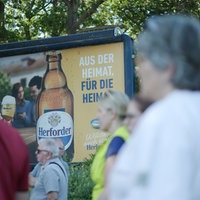 Demonstranten vor Werbetafel der Brauerei