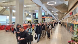 Viele Menschen warten in einer Schlange am Köln-Bonner Flughafen