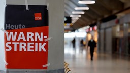Ein Plakat mit der Aufschrift "verdi - heute - Warnstreik" klebt an einer Säule im FLughafen Köln/Bonn.