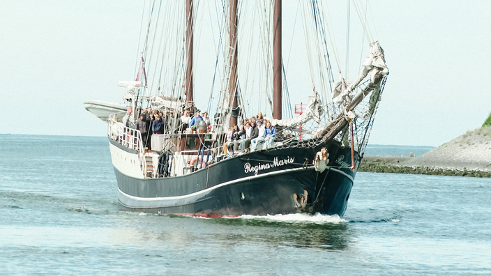 Mit der Crew und den Schülern an Deck läuft das Segelschiff Regina Maris in den Hafen von Amsterdam ein