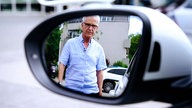 Im Seitenspiegel des Autos ist Uwe Blaschke zu sehen, der auf das Auto zuläuft.