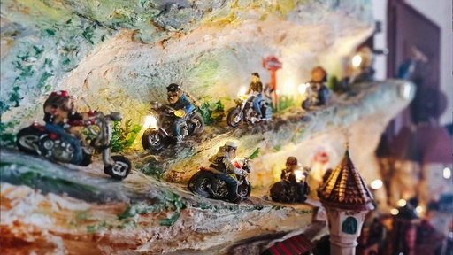 Selbstgemachte Figürchen von Motorradfahrern, die durch eine - ebenfalls gebastelte - Berglandschaft fahren.