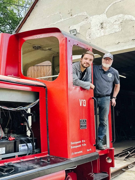 Michael Steidle und Folkert Hemmen stehen auf einer roten Lok.