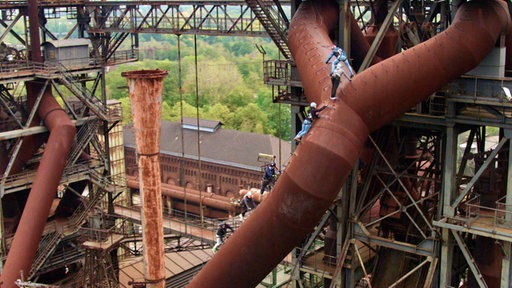 Eine Gruppe Kletterer auf den Hochöfen im Landschaftspark Duisburg.