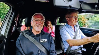 Uwe Blaschke sitzt hinter dem Lenkrad eines Autos. Neben ihm sitzt Fahrlehrer Ulf Imort. Beide schauen auf die Straße vor ihnen.