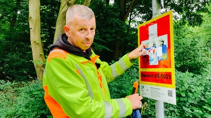 Oliver Herchenbach im Interview. Er trägt eine neongrüne Jacke. 
